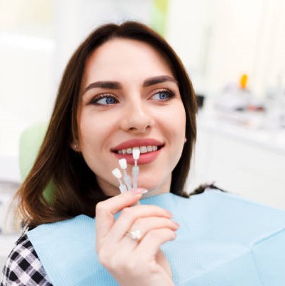 Girl chooses color of veneers at the dentist office